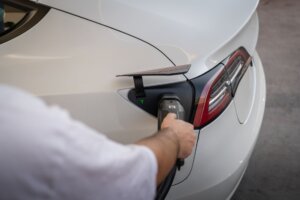 A white Tesla Model 3 plugged in at a charging point