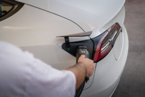 Un Tesla Model 3 blanco cargando en un punto de recarga