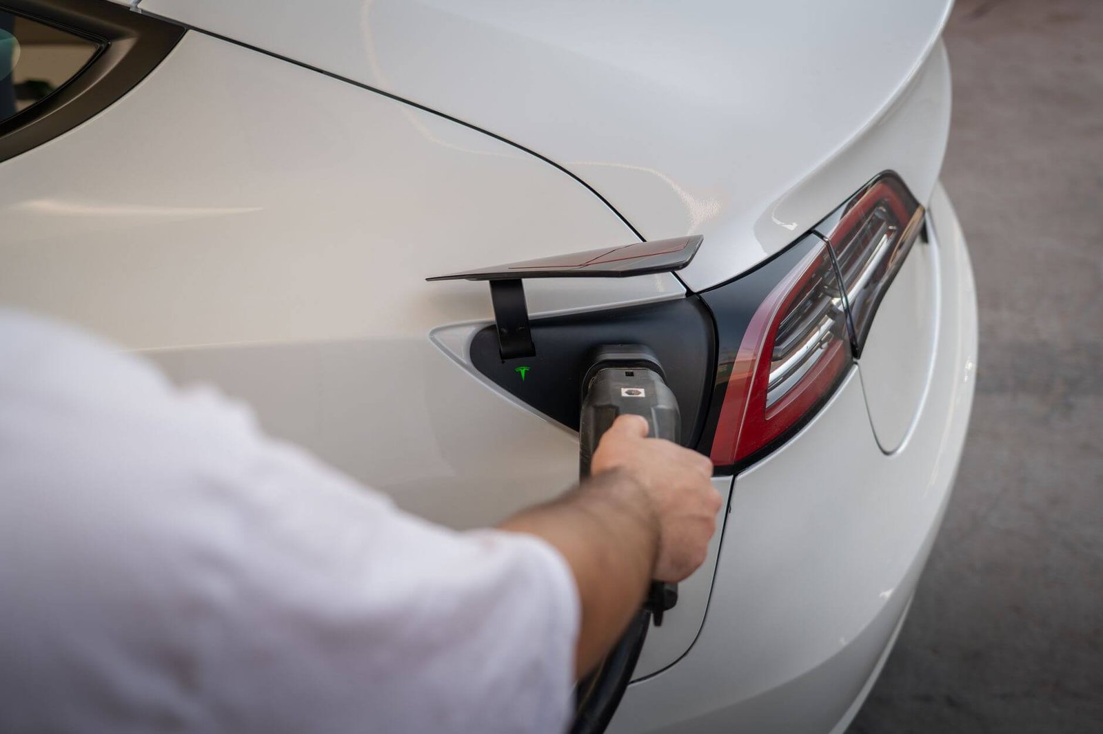 A white Tesla Model 3 plugged in at a charging point